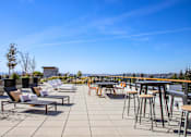 Thumbnail 34 of 49 - A patio with chairs and tables overlooking a city.