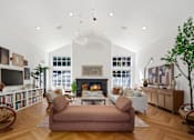 Thumbnail 17 of 38 - A living room with a fireplace, a couch, and a chair.