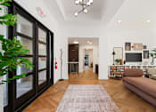Thumbnail 16 of 38 - A living room with a brown couch and a rug.