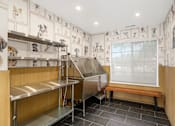 Thumbnail 26 of 38 - A kitchen with a stainless steel sink and wooden bench.