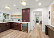 Thumbnail 25 of 38 - A kitchen with wooden floors and brown cabinets.