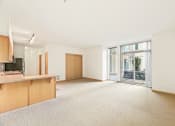 Thumbnail 23 of 42 - an empty living room with a kitchen and a balcony