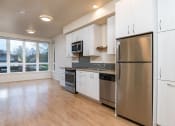 Thumbnail 11 of 33 - an empty kitchen with stainless steel appliances and white cabinets
