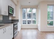 Thumbnail 1 of 33 - an empty kitchen with white cabinets and a window
