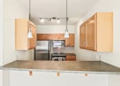 Thumbnail 22 of 42 - a kitchen with wooden cabinets and a marble counter top