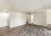 Thumbnail 19 of 40 - an empty living room with white walls and wood flooring