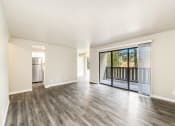 Thumbnail 17 of 40 - an empty living room with a sliding glass door to a balcony