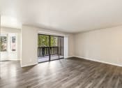 Thumbnail 18 of 40 - an empty living room with a sliding glass door to a balcony