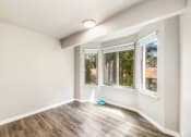 Thumbnail 15 of 40 - an empty room with wood floors and three windows