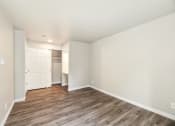 Thumbnail 21 of 40 - a living room with white walls and wood flooring
