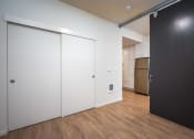 Thumbnail 23 of 33 - a bedroom with a black door and a kitchen with a refrigerator and