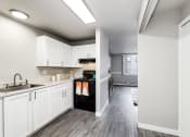 Thumbnail 10 of 15 - a kitchen with white cabinets and black appliances