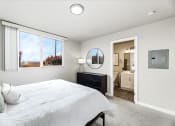 Thumbnail 12 of 15 - a bedroom with a bed and a dresser with a mirror