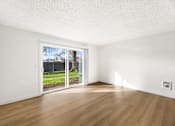 Thumbnail 27 of 49 - A room with a sliding door leading to a backyard.
