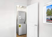 Thumbnail 32 of 49 - A white door is open to a room with a fridge and a window showing a tree.