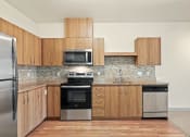 Thumbnail 8 of 20 - a kitchen with wooden cabinets and stainless steel appliances
