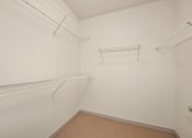 Thumbnail 12 of 20 - a walk in closet with two shelves and a hanging rack on the wall