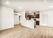 Thumbnail 20 of 32 - A kitchen with white cabinets and a wooden floor.