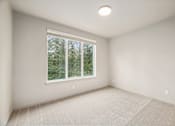 Thumbnail 15 of 32 - A room with a window and a carpeted floor.