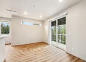 Thumbnail 19 of 32 - A room with a sliding glass door leading to a balcony.