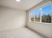Thumbnail 24 of 32 - A room with a window showing a view of trees and sky.