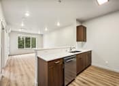 Thumbnail 18 of 32 - A kitchen with wooden cabinets and a stainless steel dishwasher.