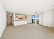 Thumbnail 21 of 42 - an empty living room with a kitchen and a large window