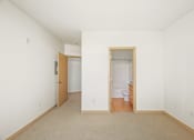 Thumbnail 33 of 42 - a living room with white walls and a door to a bathroom