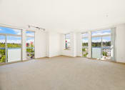 Thumbnail 24 of 42 - an empty living room with windows and a view of a river