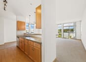 Thumbnail 19 of 42 - a kitchen with wooden cabinets and a counter top and a view of a living room