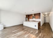 Thumbnail 7 of 38 - an empty living room and kitchen with a large island and wood floors