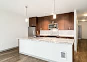 Thumbnail 12 of 38 - a kitchen with a large island with granite counter tops and wooden cabinets