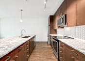Thumbnail 8 of 38 - a large kitchen with marble counter tops and wooden cabinets