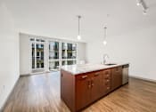 Thumbnail 1 of 38 - a large kitchen with wood floors and a large island in the middle