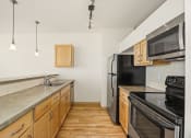 Thumbnail 15 of 42 - an empty kitchen with black appliances and wooden cabinets