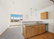 Thumbnail 25 of 42 - an empty kitchen with wooden cabinets and a sink and a window