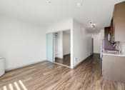 Thumbnail 9 of 38 - a living room and kitchen with wood flooring and white walls