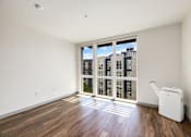 Thumbnail 4 of 38 - an empty living room with a large window and hardwood floors