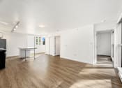 Thumbnail 8 of 26 - A room with white walls and wooden flooring, furnished with a desk and a cabinet.