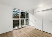 Thumbnail 5 of 26 - A room with a white door and a window with a white frame.