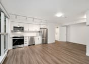Thumbnail 4 of 26 - A kitchen with stainless steel appliances and wooden floors.