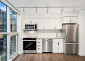 Thumbnail 3 of 26 - A modern kitchen with stainless steel appliances and white cabinetry.