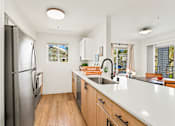 Thumbnail 25 of 34 - a kitchen with a large island and a stainless steel refrigerator