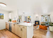 Thumbnail 23 of 34 - a kitchen with an island and a living room with a fireplace