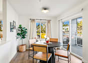 Thumbnail 27 of 34 - a dining room with a table and chairs and a balcony