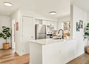 Thumbnail 24 of 34 - a kitchen with a white counter top and a stainless steel refrigerator