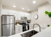 Thumbnail 4 of 20 - a kitchen with white cabinets and stainless steel appliances