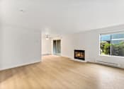 Thumbnail 3 of 26 - A modern living room with a fireplace and a view of the backyard.