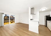 Thumbnail 33 of 49 - A kitchen with a white counter and wooden floors.