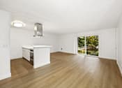 Thumbnail 25 of 49 - A white kitchen with wooden floors and a window.